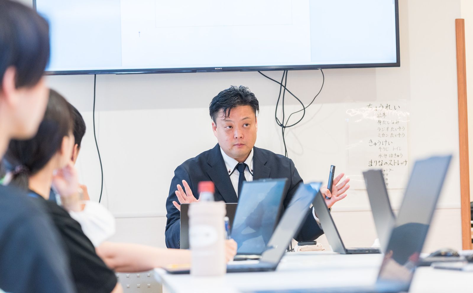 身ぶりを交えて参加者に説明している様子
